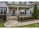 Inviting front porch with stone accents, seating, and decorative wreath on front door at 8941 Vickery Ln, Harrisburg, NC 28075
