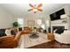 Inviting living room with leather sectional sofa, fireplace, ceiling fan, and wood floors at 8941 Vickery Ln, Harrisburg, NC 28075
