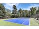Well-maintained blue tennis court in a lush green community, perfect for recreational play and exercise at 8941 Vickery Ln, Harrisburg, NC 28075
