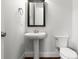Small bathroom with pedestal sink, toilet, mirror, and dark hardwood flooring at 917 Herrons Ferry Rd, Rock Hill, SC 29730