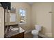 Bathroom featuring vanity with a granite countertop, toilet, and a window to let in natural light at 10129 Loch Lomond Dr, Charlotte, NC 28278