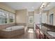 Bright bathroom featuring soaking tub, tiled floors, and double sink vanity at 10129 Loch Lomond Dr, Charlotte, NC 28278