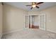 The bedroom boasts neutral walls, carpet, a ceiling fan and a view into an adjacent space through french doors at 10129 Loch Lomond Dr, Charlotte, NC 28278