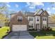Charming two-story home with stone accents, a two-car garage, manicured lawn, and a welcoming front porch at 10129 Loch Lomond Dr, Charlotte, NC 28278