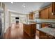 Open-concept kitchen with granite countertops, stainless steel appliances, kitchen island, and hardwood flooring at 10129 Loch Lomond Dr, Charlotte, NC 28278
