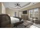 Staged primary bedroom with tray ceiling, large windows, dresser, and a decorative chair at 10129 Loch Lomond Dr, Charlotte, NC 28278