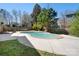 Inviting in-ground pool surrounded by a concrete patio, lush greenery, and a fenced yard at 105 Easy St, Mooresville, NC 28117