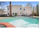 Backyard oasis featuring an in-ground pool, patio with seating, and mature trees at 105 Easy St, Mooresville, NC 28117