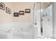 Bathroom featuring a large soaking tub, a glass enclosed shower, and decorative wall art at 105 Easy St, Mooresville, NC 28117