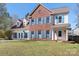 Charming two-story brick home featuring blue shutters, a well-manicured lawn, and a covered porch at 105 Easy St, Mooresville, NC 28117