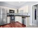 Efficient kitchen featuring stainless steel appliances, white cabinets, and a breakfast bar at 105 Easy St, Mooresville, NC 28117