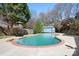 Inviting in-ground pool surrounded by a concrete patio, lush greenery, and a fenced yard at 105 Easy St, Mooresville, NC 28117