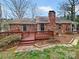 Brick home exterior with a wooden deck and patio area, perfect for outdoor entertaining at 105 Southfork Ln, Belmont, NC 28012