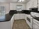 Functional kitchen features white cabinets, black countertops, and modern appliances at 105 Southfork Ln, Belmont, NC 28012