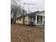 The exterior shot shows the side of the house, highlighted by a chimney, bare trees, and a trash can at 1140 Mt Vernon Rd, Woodleaf, NC 27054