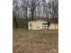 Exterior view of detached garage with doors, located on overgrown lot at 1140 Mt Vernon Rd, Woodleaf, NC 27054