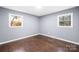 Bedroom featuring hardwood floors, two windows, freshly painted gray walls and trim at 1203 Northwoods Dr, Kings Mountain, NC 28086