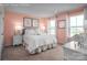 This bedroom has carpet, two windows, bedside tables, a bed with white bedding and feminine decorations at 1240 Cottage Green Dr # 0132, Monroe, NC 28112