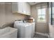 This laundry room has a window, washer, dryer, a sink and cabinets at 1240 Cottage Green Dr # 0132, Monroe, NC 28112