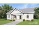 Charming exterior featuring vertical siding, a gray metal roof, a covered entry porch and a well-manicured lawn at 1469 32Nd Sw St, Hickory, NC 28602