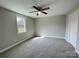 Neutral bedroom features gray carpet, a ceiling fan, and a bright window at 1479 Southwest Blvd, Newton, NC 28658