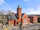 The exterior of a vintage brick building with a steeple, set against a blue sky with street level car and crosswalk at 167 Saluda St, Chester, SC 29706