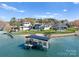 Aerial view of waterfront homes featuring a private dock, infinity pools, and manicured lawns at 18601 Bluff Point Rd, Cornelius, NC 28031