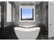 Beautiful bathroom featuring a luxurious soaking tub and sleek black marble tile at 18601 Bluff Point Rd, Cornelius, NC 28031