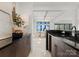 Contemporary kitchen with black countertops and lake view through dining area at 18601 Bluff Point Rd, Cornelius, NC 28031