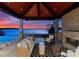 Cozy outdoor lounge with a fireplace, wicker furniture, and stunning lake views at sunset at 18601 Bluff Point Rd, Cornelius, NC 28031