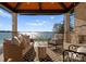 Relaxing covered outdoor patio featuring comfortable seating, a stone fireplace, and breathtaking water views at 18601 Bluff Point Rd, Cornelius, NC 28031