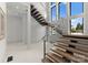 Modern staircase with wood treads and glass railing with an abundance of natural light at 18601 Bluff Point Rd, Cornelius, NC 28031