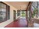 Inviting covered front porch with brick columns, swing, and view to the front yard at 211 W 6Th Ave, Gastonia, NC 28052