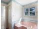 Bathroom featuring a pink tub, classic wallpaper, and a bright window for natural light at 2129 Belle Chase Dr, Rock Hill, SC 29732