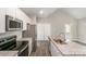 Well-lit kitchen featuring stainless steel appliances, white cabinets, and granite countertops at 213 Shannonhouse W St, Shelby, NC 28152