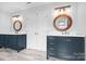 Bathroom with double sink vanities, decorative round mirrors and grey wood look tile floors at 215 Whitegrove Dr, Fort Mill, SC 29715