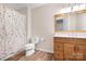 Neutral bathroom with a wood vanity, a white toilet and shower with a floral shower curtain at 215 Whitegrove Dr, Fort Mill, SC 29715