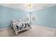 Bedroom featuring blue walls, a ceiling fan, patterned bedding, and natural light from a window at 215 Whitegrove Dr, Fort Mill, SC 29715