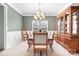 Traditional dining room with wainscoting, chandelier, window and hardwood hutch at 215 Whitegrove Dr, Fort Mill, SC 29715