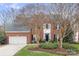 Beautiful two-story brick home featuring mature trees and professionally landscaped front yard at 215 Whitegrove Dr, Fort Mill, SC 29715