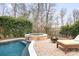 Backyard pool and hot tub featuring a waterfall, fire pit, lounge chair, and privacy landscaping at 215 Whitegrove Dr, Fort Mill, SC 29715