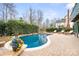 Inviting backyard pool with lounge chairs, brick surround, and a lush landscaped garden at 215 Whitegrove Dr, Fort Mill, SC 29715