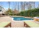 Inviting backyard pool with lounge chairs, brick surround, and a lush landscaped garden at 215 Whitegrove Dr, Fort Mill, SC 29715