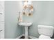 Powder room featuring a pedestal sink, nautical themed round mirror and toilet at 215 Whitegrove Dr, Fort Mill, SC 29715