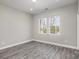 Bright bedroom featuring two windows, neutral walls, and gray wood floors at 220 Shannonhouse W St, Shelby, NC 28152