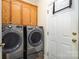 Laundry room with front load washer and dryer, wood cabinets and white door at 2713 Firethorn Ct # 48, Gastonia, NC 28056