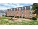 Brick apartment building with a grass backyard, an outdoor seating area, and mature trees at 300 N Fulton St # 12, Salisbury, NC 28144