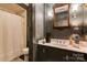 Charming bathroom with marble countertop, dark blue walls, and classic fixtures around the oval mirror at 300 N Fulton St # 12, Salisbury, NC 28144