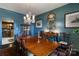 Elegant dining room showcasing blue walls, chandelier, and access to kitchen at 300 N Fulton St # 12, Salisbury, NC 28144
