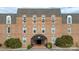 A brick building exterior featuring symmetric windows under a gray roof, with shrubbery and an entrance awning at 300 N Fulton St # 12, Salisbury, NC 28144